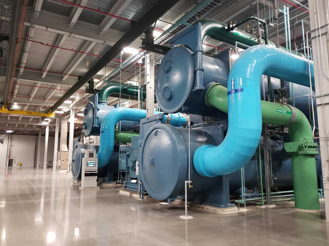 Industrial chiller room with large blue chillers and mechanical equipment